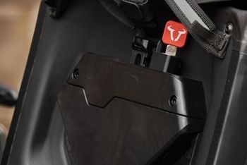 Red charging device with a logo inserted into a black storage compartment.